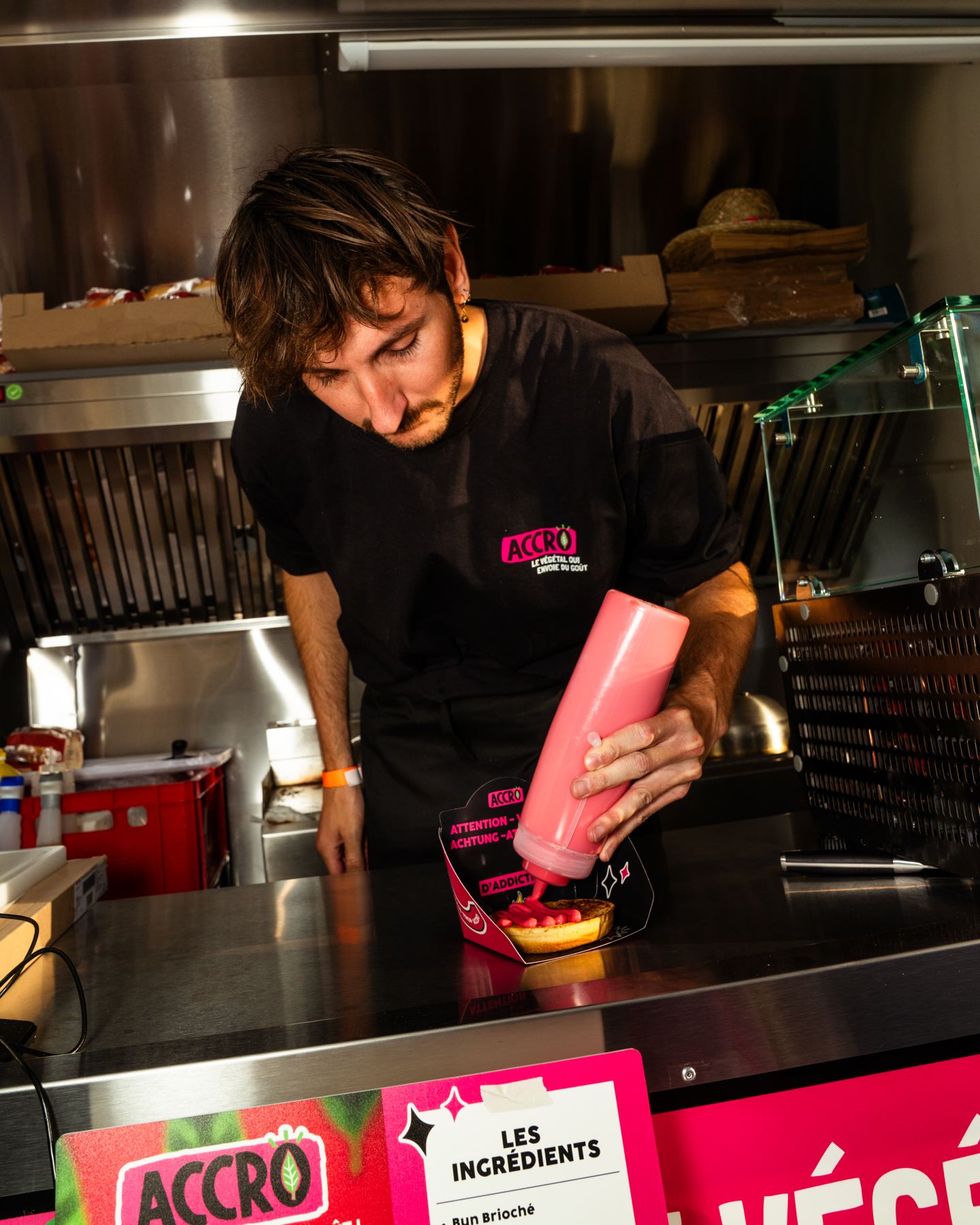 Salsa sobre una hamburguesa, en la encimera de acero inoxidable de un food truck