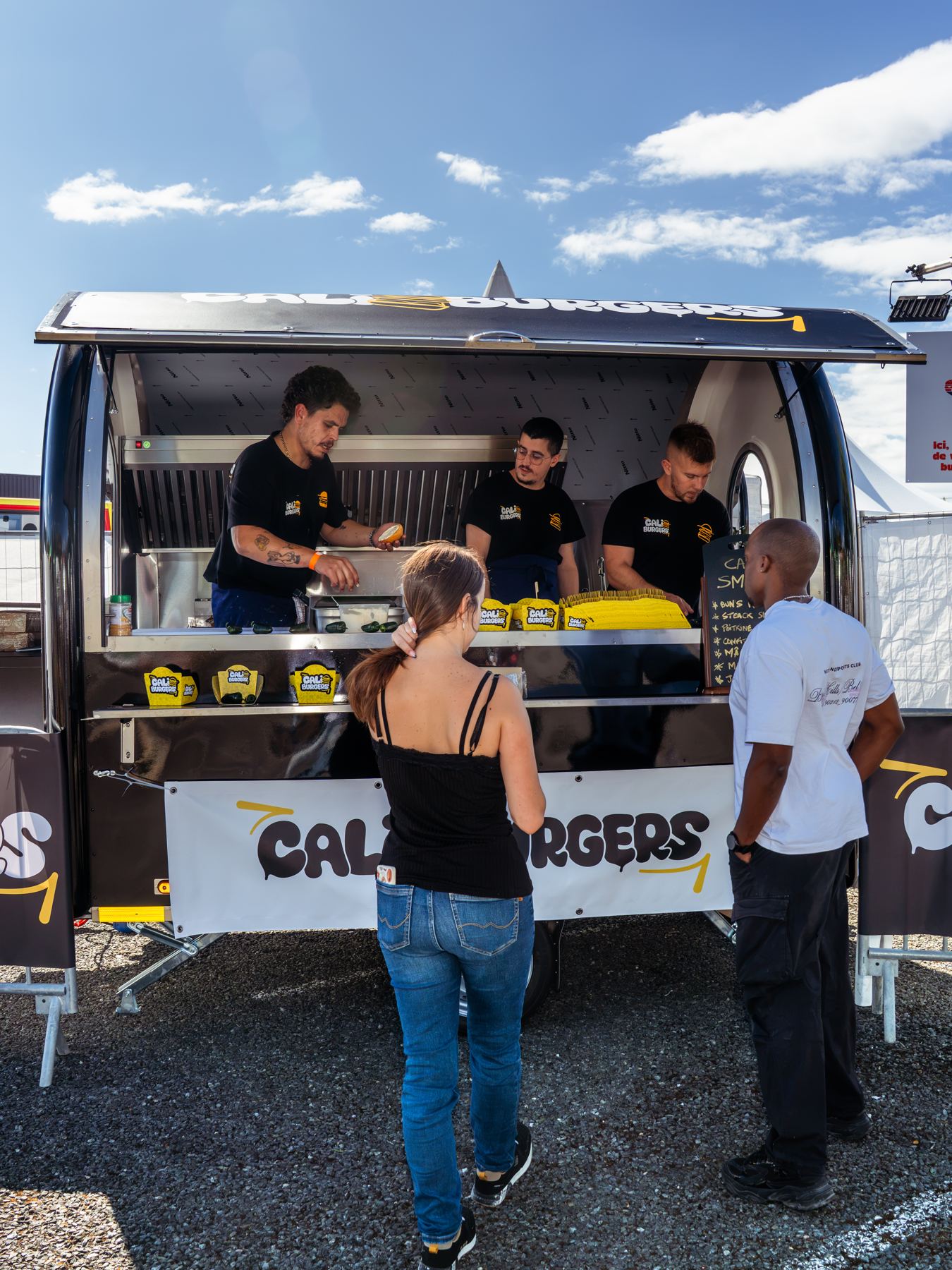 Clientes en el mostrador de un remolque food truck de hamburguesas