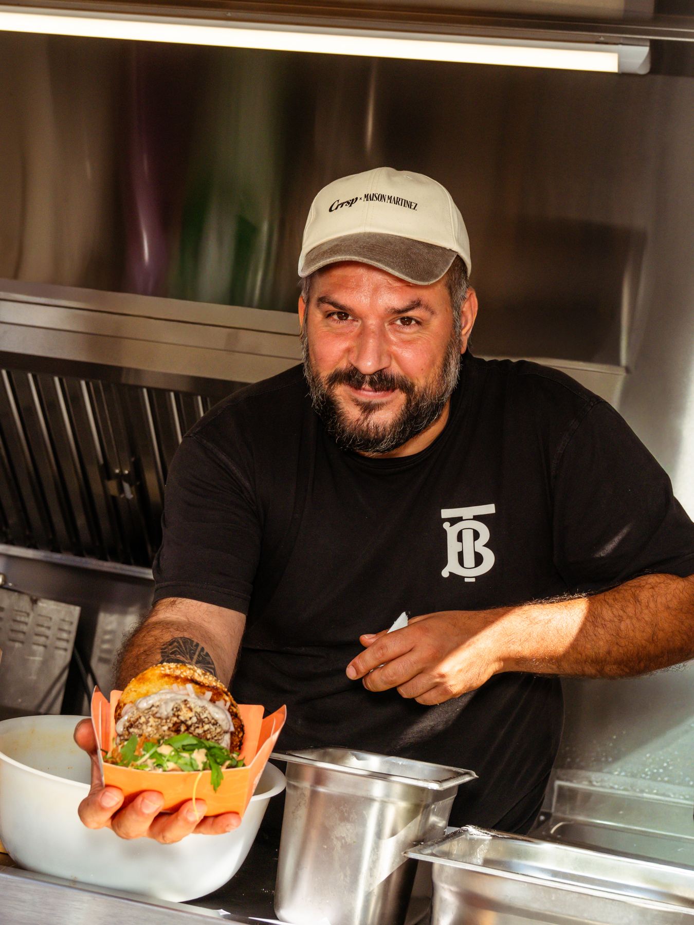 Un cocinero presenta un plato en su remolque food truck