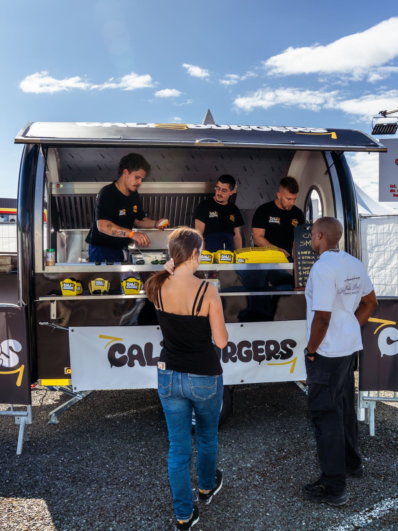 Clientes en el mostrador de un remolque food truck de hamburguesas